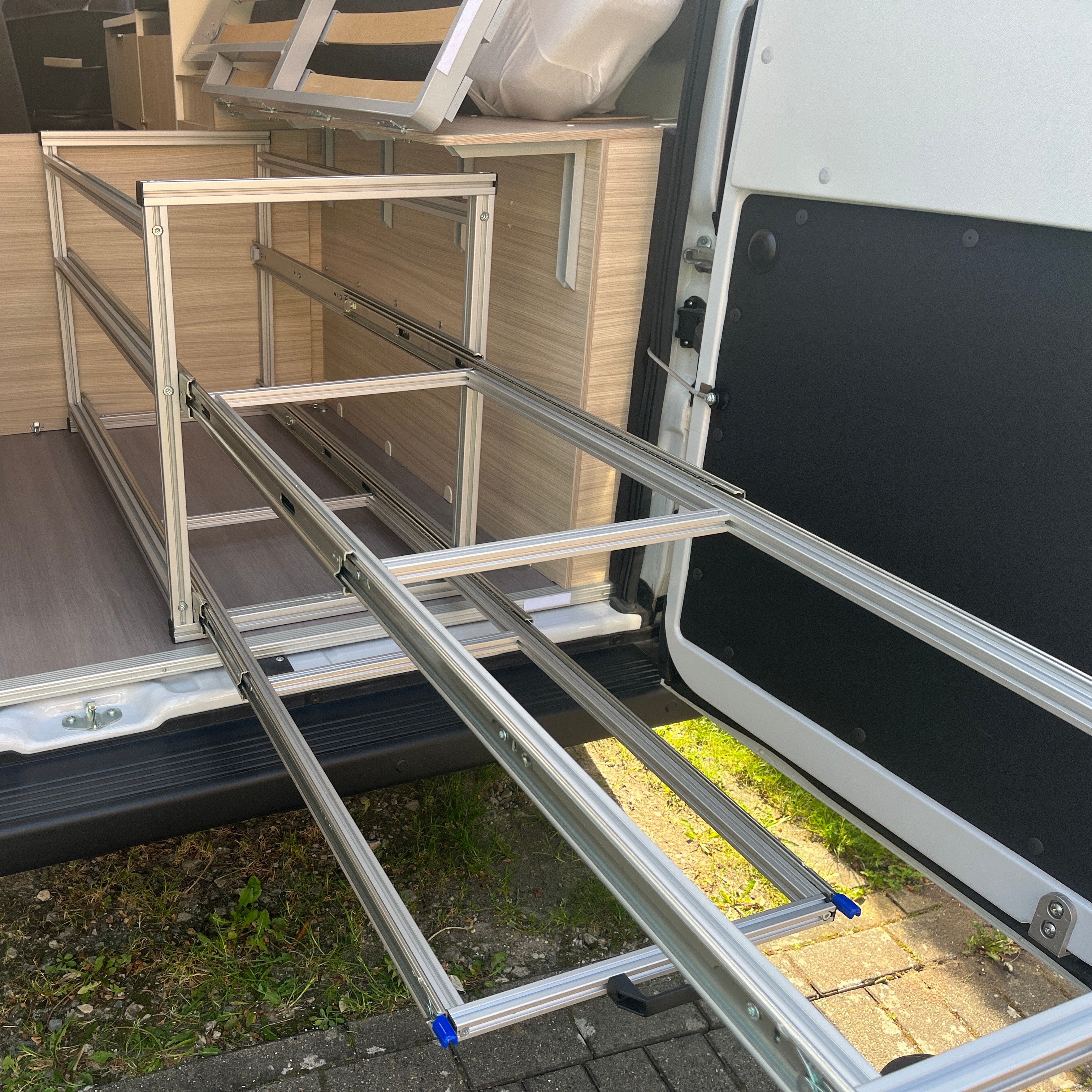 Heckauszug mit zwei ausziehbaren Ebenen im Adria Twin 600, vollständig herausgezogen zur Stauraumoptimierung.