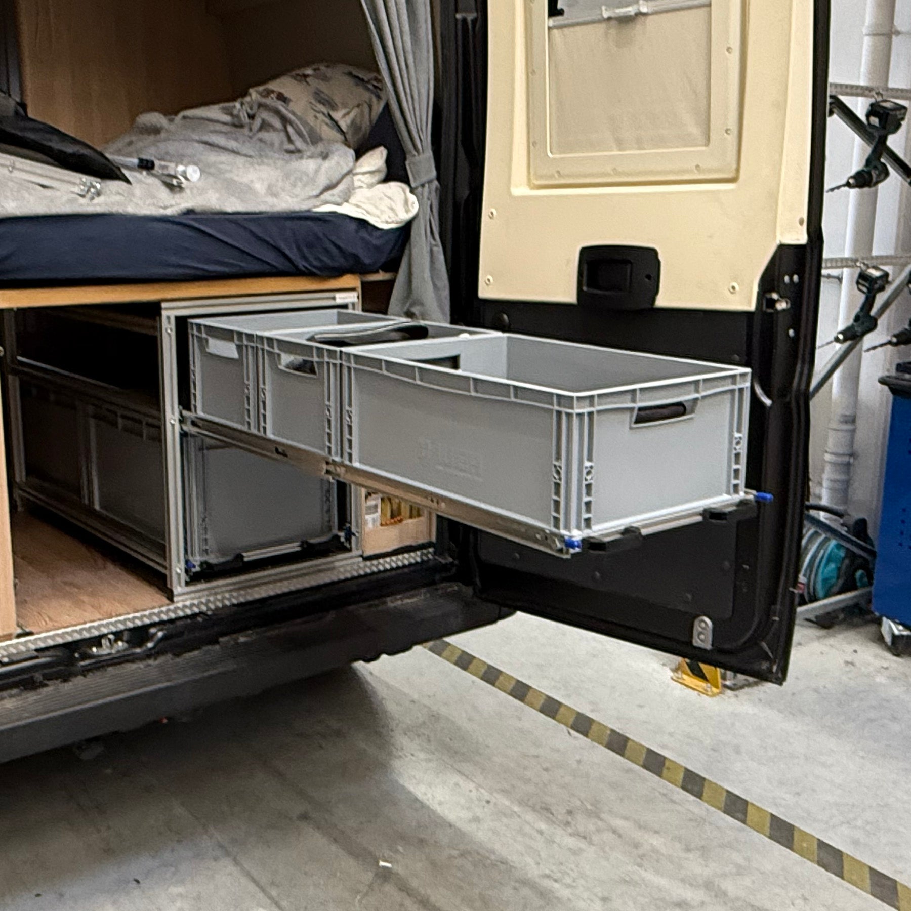 Heckstauraum mit verkürztem Rahmen und überstehenden Vollauszügen, bestückt mit Euroboxen in zwei Höhen für optimale Raumnutzung.