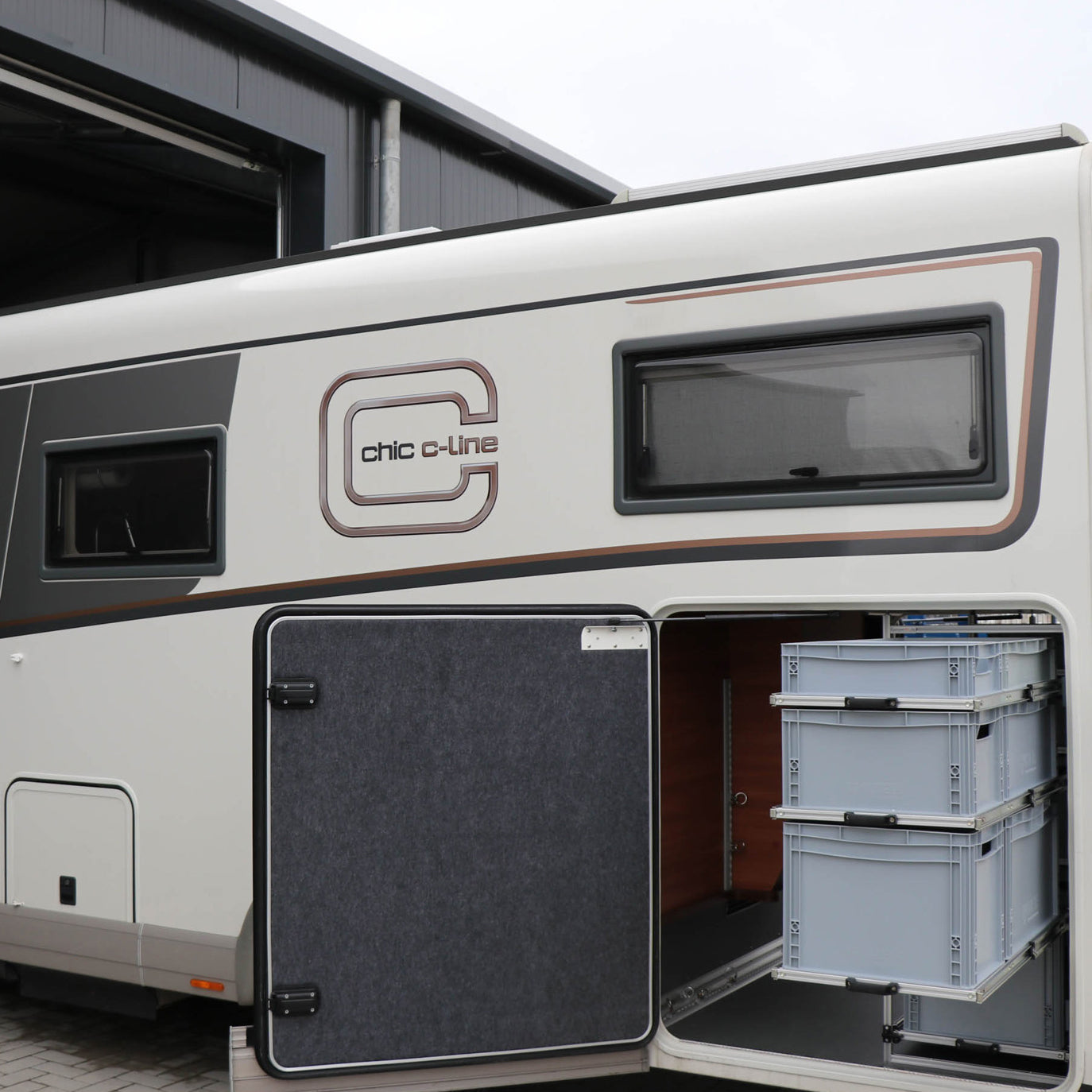 Ordentlich sortierte Campingausrüstung in ausziehbaren Euroboxen-Regalen im Wohnmobil.